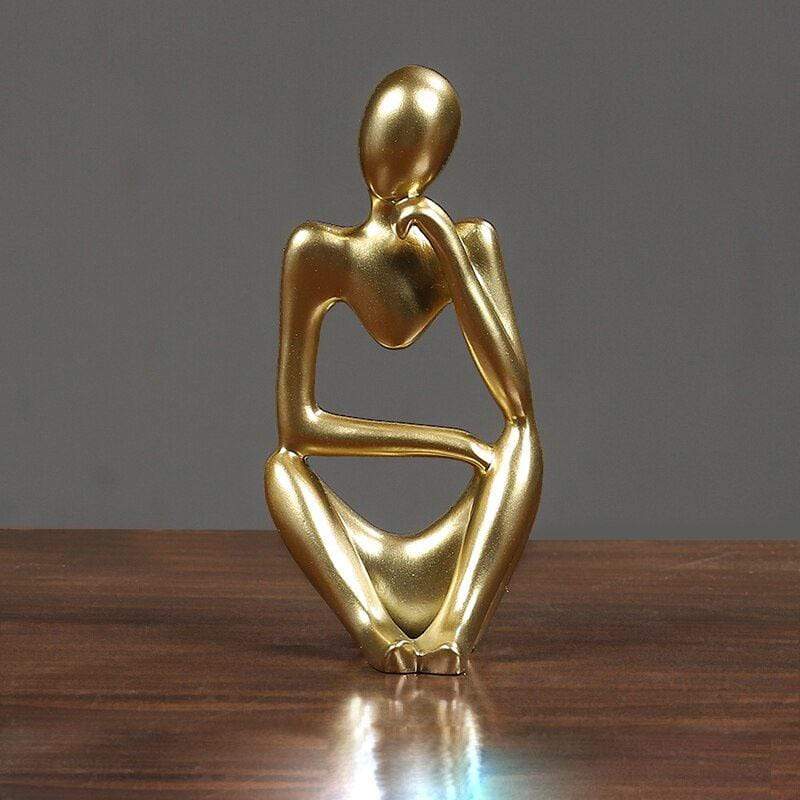 Gold Thinking sculpture decor on a table